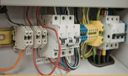 Industrial electrical enclosure with circuit breakers, terminal blocks, and dense wiring — the kind of high-noise environment where CAN bus isolation is critical.