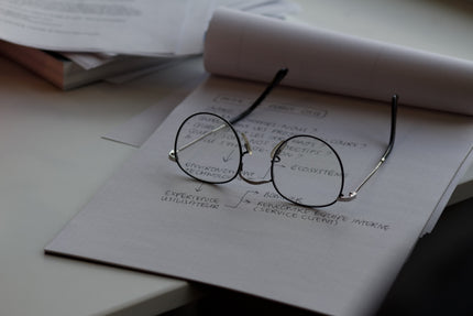 reading glasses sitting on a pad of paper