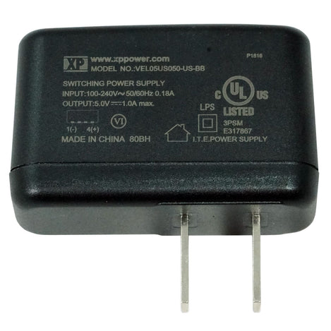 A black power supply adapter with two metal pins, featuring white printed specifications and certification logos on its top surface.