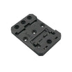 A black plastic mounting bracket or adapter plate with pre-drilled holes and a small molded marking 